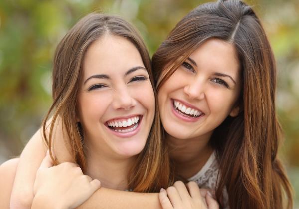 Two Women Friends Laughing With A Perfect White Teeth